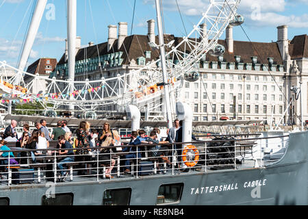 London, UK, 21. Juni 2018: Viele Touristen in Boot Schiff pub Sitzen genannt Tattershall Schloss auf der Themse mit Blick auf London Eye in r Stockfoto