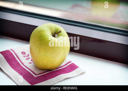 Apple auf eine Serviette auf dem Fensterbrett. Stockfoto
