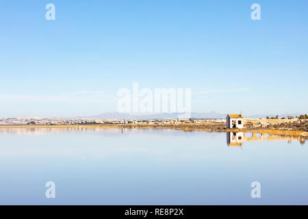 Alte Ruine mit einem bleibt eines Aquädukts am Rande einer salzhaltigen See, sowohl im Wasser als auf dem blauen Hintergrund der Himmel widerspiegeln. Stockfoto