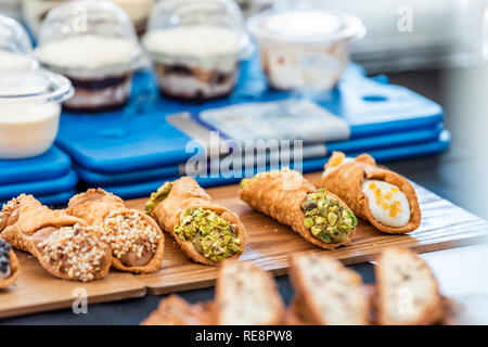 Viele gelb orange grün Pistazie italienische Dessert Stücke auf Holz- fach Anzeige in Street Food Markt oder Catering Bäckerei Cafe mit Muttern und Parfait i Stockfoto
