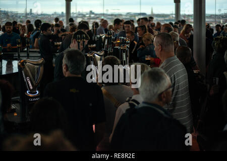 Überfüllte Gravity Bar im Guinness Storehouse Dublin, Irland, und Gäste, die sich in dem geschäftigen dunklen und stimmungsvollen Pub mit Guinness Stout tummeln. Stockfoto