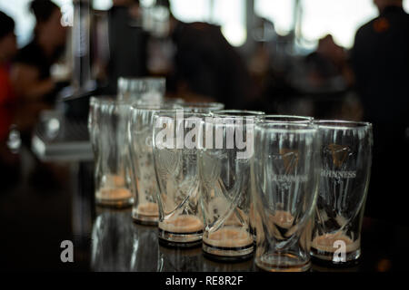 Leere Guinness-Gläser in überfüllter Bar und Leute im Hintergrund im Gravity Bar Guinness Storehouse Dublin, Irland Stockfoto