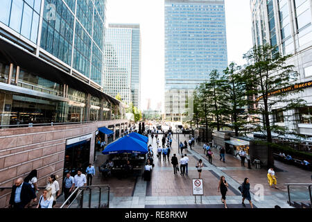 London, UK, 26. Juni 2018: Leute Pendler außerhalb während der morgendlichen Fahrt zum rush hour in Canary Wharf, Docklands mit moderner Architektur Uhren Stockfoto
