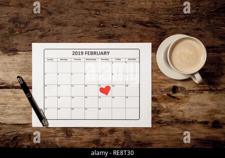 Ansicht von oben konzeptionelle Bild von 2019 Februar Kalender mit roten Herzen auf der 14. und Kaffee auf rustikalen vintage Tabelle, für Valentinstag bereit Stockfoto