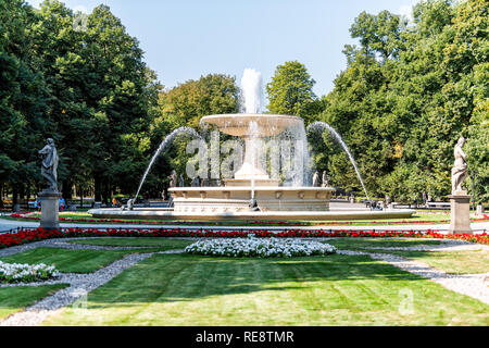 Warschau, Polen - 23 August, 2018: die Menschen Touristen durch Brunnen im Sommer Saxon Gardens Park mit Spritzen spritzen Skulpturen Stockfoto