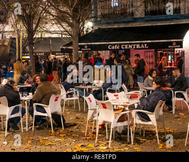 Menschen an Tischen im Freien an einem kühlen Winterabend in einem Cafe in der Alameda de Hercules in Sevilla, Spanien Stockfoto