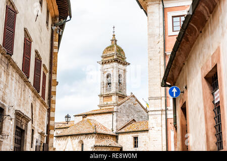 San Quirico d'Orcia, Italien Straße in der Stadt Dorf in der Toskana während der sonnigen Sommertag und berühmten Glockenturm der Kirche zwischen Gasse Stockfoto