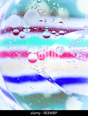 Öltropfen auf einer Wasseroberfläche mit bunten Hintergrund Stockfoto