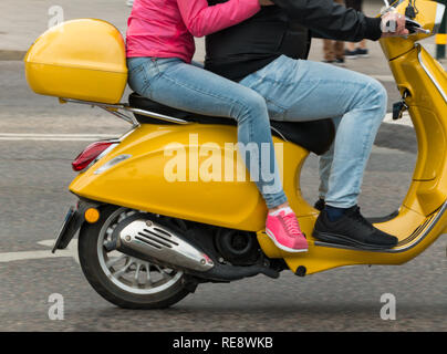 Zwei Menschen, ein gelber Roller Stockfoto