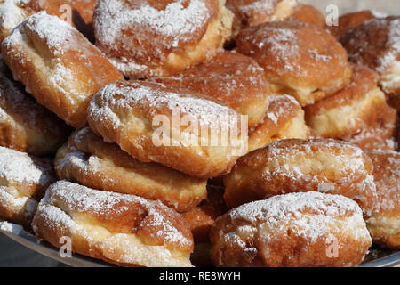 Gebratene Vanillepudding donuts bestreut mit Puderzucker, auf das Fach Closeup übereinander gestapelt Stockfoto