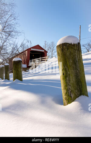 Schneeverwehungen gegen den Zaun Beiträge auf einer extrem kalten Wintern Tag im historischen Roten Covered Bridge in Princeton, Illinois Stockfoto