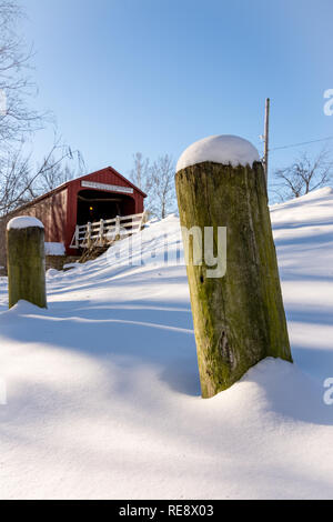 Schneeverwehungen gegen den Zaun Beiträge auf einer extrem kalten Wintern Tag im historischen Roten Covered Bridge in Princeton, Illinois Stockfoto