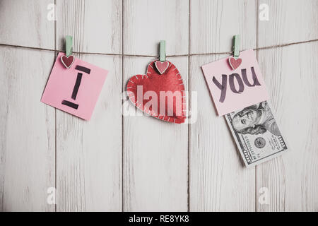 Valentines Tag Karte. Herz und Blatt Papier am Seil mit Worten der Liebe auf alten weißen Holz Hintergrund Stockfoto