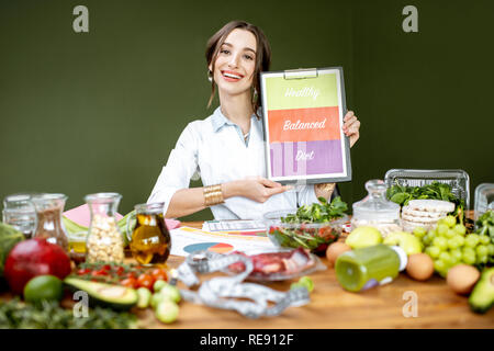 Ernährungsberater Förderung gesunden, ausgewogenen Essen an den Tisch voller variuos Produkte sitzen Stockfoto