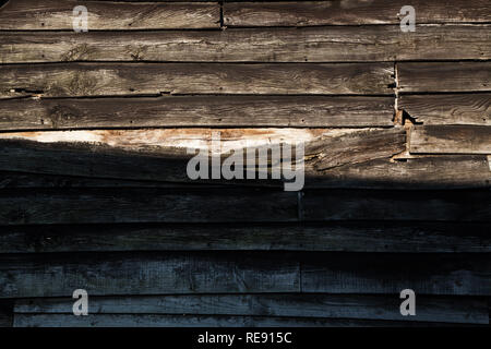 Federwild aus Holz auf der Seite des Bauernhofes. Verwitterte verschlechternden Zustand, schwarz lackiert. Stockfoto