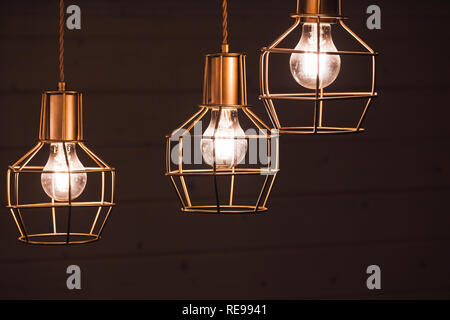 Drei Glühlampen, gelb LED-Beleuchtung Elemente mit Metall Wire frame Lampenschirme, Foto mit selektiven Fokus abgedeckt Stockfoto
