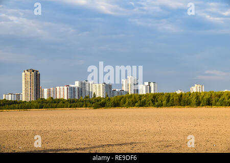 Blick auf einem abgeernteten Feld auf den Satelliten Stadt Gropiusstadt in Berlin-Neukölln von der Sonne beleuchtet. Stockfoto
