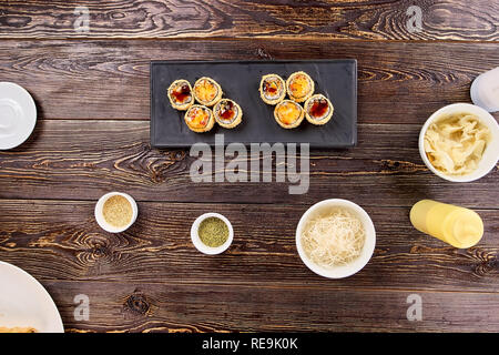 Köstliches Sushi Rollen auf schwarzen, rechteckigen Platte. Appetitlich Satz von japanischen Sushi an der Platte. Stockfoto