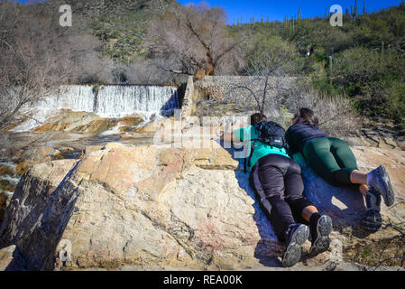 Wanderer eine Pause ein und legte sich auf den Felsen vor dem Sabino Damm Ost im Sabino Canyon Recreation Area, in der Nähe von Tucson, AZ Stockfoto