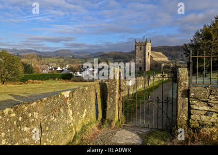 Die imposante Kirche St. Michael und alle Engel stehend über dem schönen Dorf Hawkshead mit Blick auf Latterbarrow und die fernen Fells Stockfoto