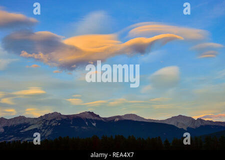 Eine linsenförmige Wolken die Form eines Vogels fliegen über Roche Bonhomme Bergkette im Jasper National Park in Alberta, Kanada. Stockfoto