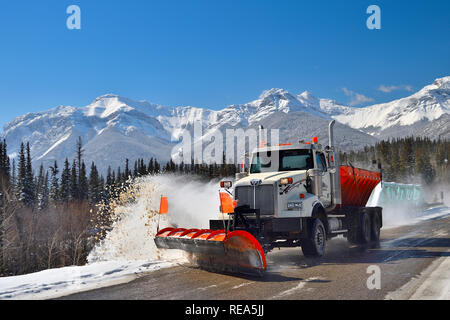 Ein LKW pflügt Schnee auf einer zweispurigen Autobahn in Die felsigen Berge in der Nähe von Brule Alberta Canada Stockfoto