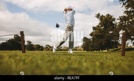 Professioneller Golfspieler, Schuß auf den Golfplatz. Ältere Golf player Schwingen Golf Club auf dem Grün. Stockfoto