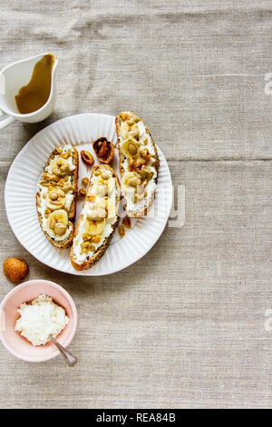 Toast mit Ricotta, Bananen und Nüsse flach Stockfoto