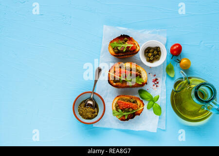 Frisch geräucherten Lachs Toasts mit Rucola, Pesto und Kapern flach. Stockfoto