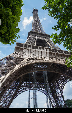 Überragt - geringe Aussicht auf den Eiffelturm zwischen Bäumen. Paris, Frankreich Stockfoto