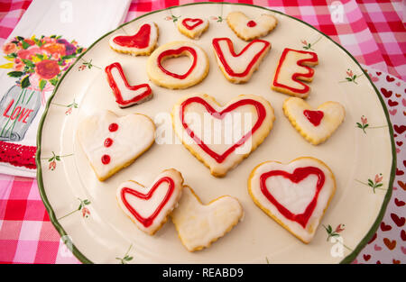 Valentinstag Cookies im Herzen Formen in Weiß mit rotem Rahmen und Design gefrostet. Stockfoto