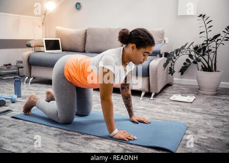 Dunkelhäutige Frau mit gebunden Haar über den Rücken verbiegen Stockfoto