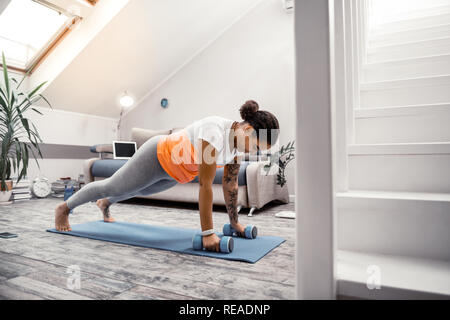 Zuversichtlich strenge Afrikanische amerikanische Dame mit Hanteln während des Trainings Stockfoto