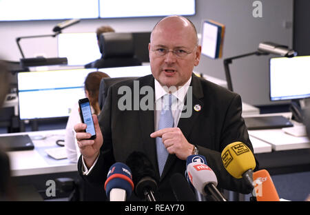 Bonn, Deutschland. Jan, 2019 21. Arne Schönbohm, Präsident des Bundesamtes für Sicherheit in der Informationstechnik (BSI), Hält ein Smartphone in der Hand auf nationaler der BSI-IT-Situation. Quelle: Henning Kaiser/dpa/Alamy leben Nachrichten Stockfoto