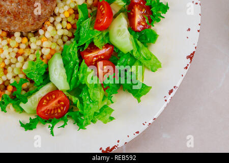 Gesunde couscous Pastetchen mit Salat und Schweineschnitzel Stockfoto