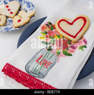 Valentinstag Cookies im Herzen Formen in Weiß mit rotem Rahmen und Design gefrostet. Stockfoto