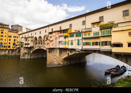 Boote warten auf Ihre Kunden unter bunten Ponte Vecchio - eine Brücke Hosting viele Juweliergeschäfte, überquert den Fluss Arno. Florenz, Italien Stockfoto