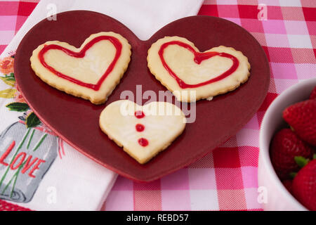 Valentinstag Cookies im Herzen Formen in Weiß mit rotem Rahmen und Design gefrostet. Stockfoto