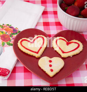 Valentinstag Cookies im Herzen Formen in Weiß mit rotem Rahmen und Design gefrostet. Stockfoto