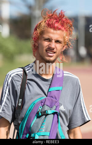 Durban, Südafrika - Januar 07th, 2019: Porträt einer jungen kaukasischen Mann mit Haare gefärbt blond und rote Farbe, die Kamera im Freien in Durban, So Stockfoto