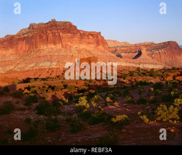 USA, Utah, Capitol Reef National Park, Sonnenuntergang am Schloss und andere Sandstein Felsformationen entlang der Waterpocket Fold; Ansicht von Osten Panorama Punkt. Stockfoto