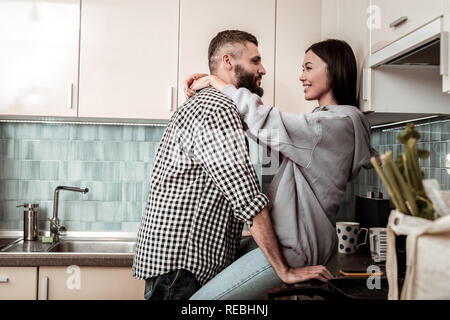 Pflege gut aussehender Mann, der zu seiner Freundin und umarmte ihre Stockfoto