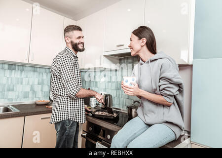Fröhliche bärtigen Mann Gefühl in der Küche das Abendessen beteiligt Stockfoto