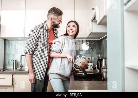 Fürsorglichen Mann in die Küche, wo Frau Abendessen kochen kommen Stockfoto