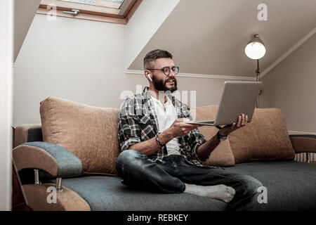 Nette junge Mann an seinem Laptop Bildschirm schaut Stockfoto