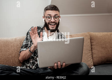 Freudige fröhlicher junger Mann wünscht seinem Freund Stockfoto