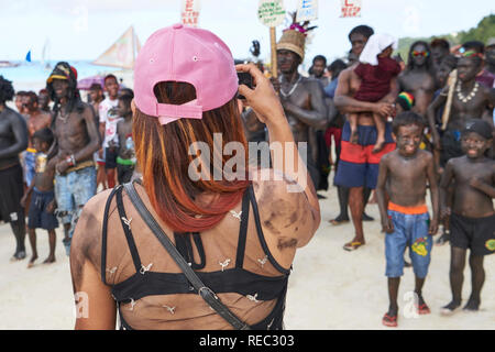 Asiatische Mitte Alter weibliche Touristen fotografieren an der Ati-Atihan-Parade entlang der weißen Strand auf der Insel Boracay, Aklan Provinz, Philippinen. Stockfoto