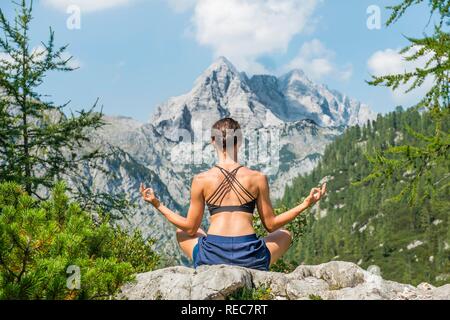 Junge Frau, meditieren, Blick auf Watzmann und Berglandschaft, Nationalpark Berchtesgaden, Berchtesgadener Land Stockfoto