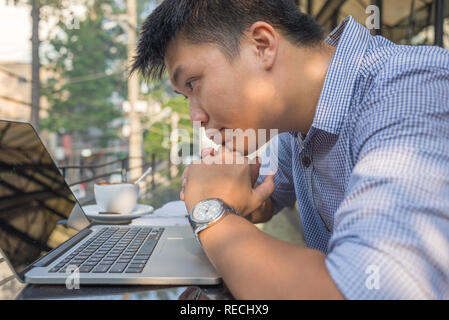 Asiatische Investor gerade die Änderung der Börse auf Laptop Stockfoto