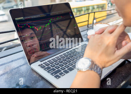 Junge Investor gerade die Änderung der Börse auf Laptop Stockfoto